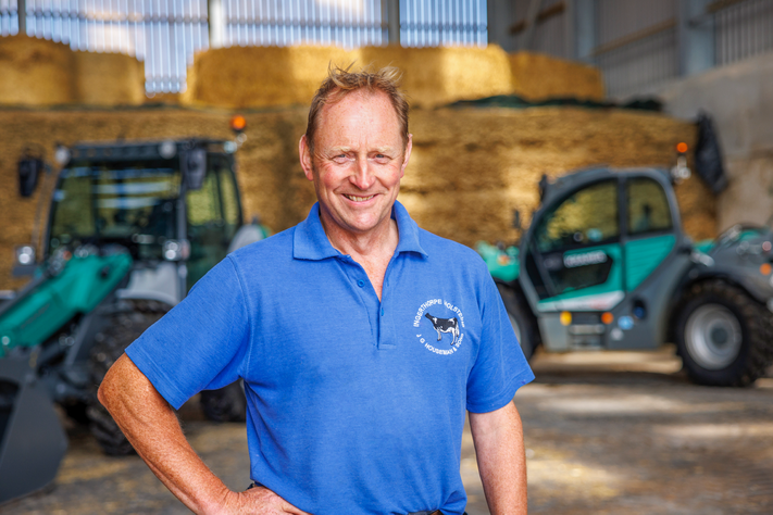 Landwirt Houseman steht vor einem Kramer Radlader und einem Kramer Teleskoplader