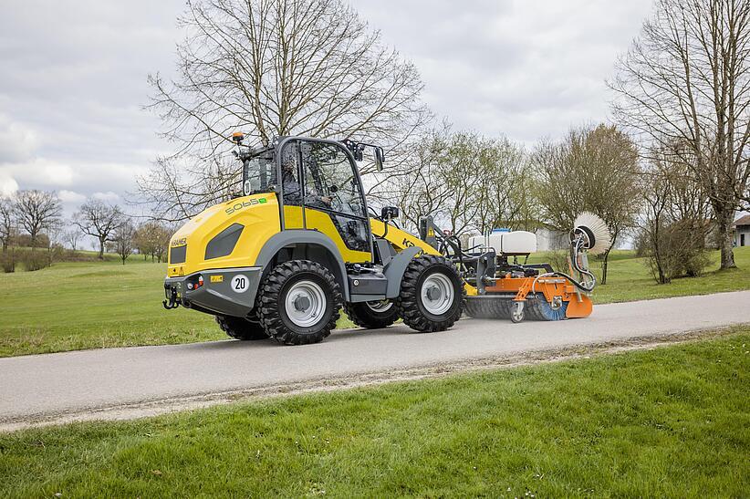 Radlader 5065e mit Kehrmaschine im Park