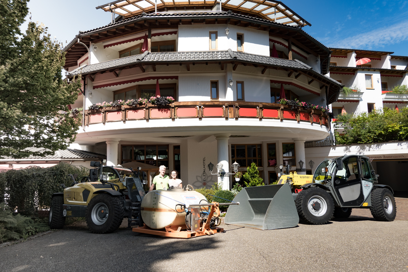 Dwa ładowarki teleskopowe Kramer przed hotelem Eltztalhotel