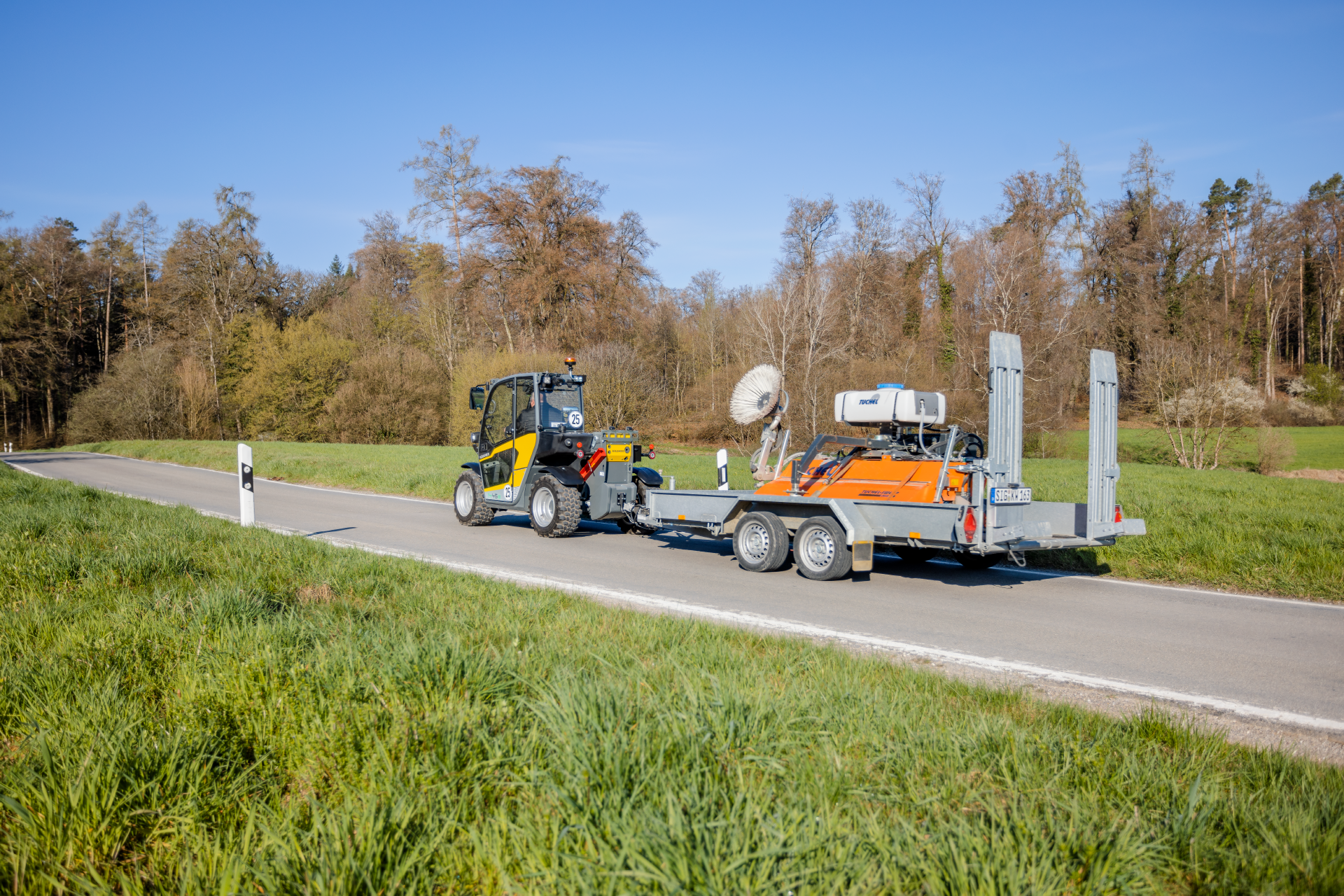 The fully electric Kramer telehandler 1445e while driving with a trailer.