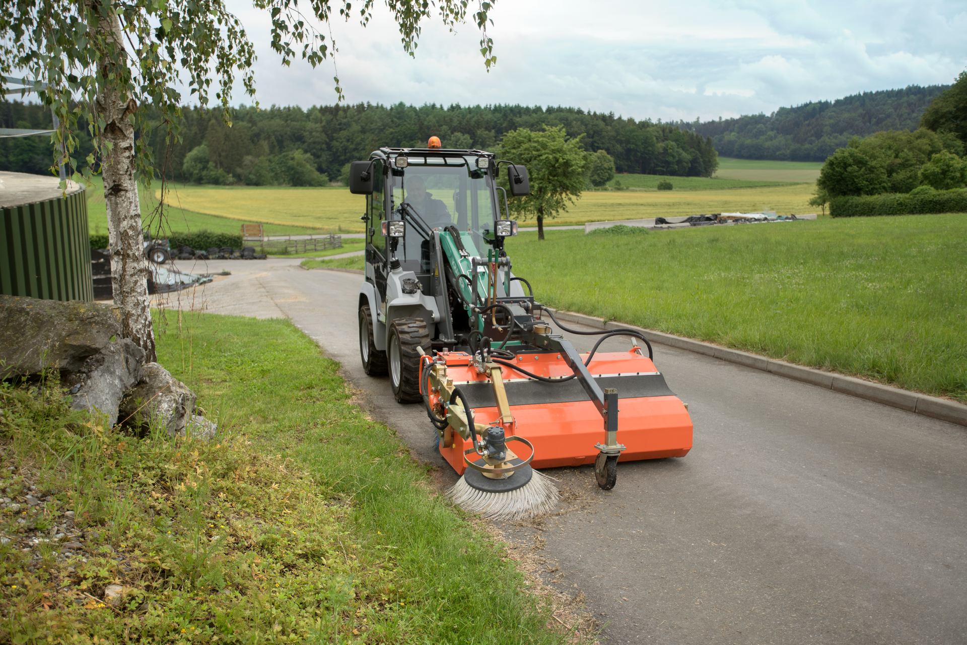 The compact KL12.5 while brushing a yard entrance.