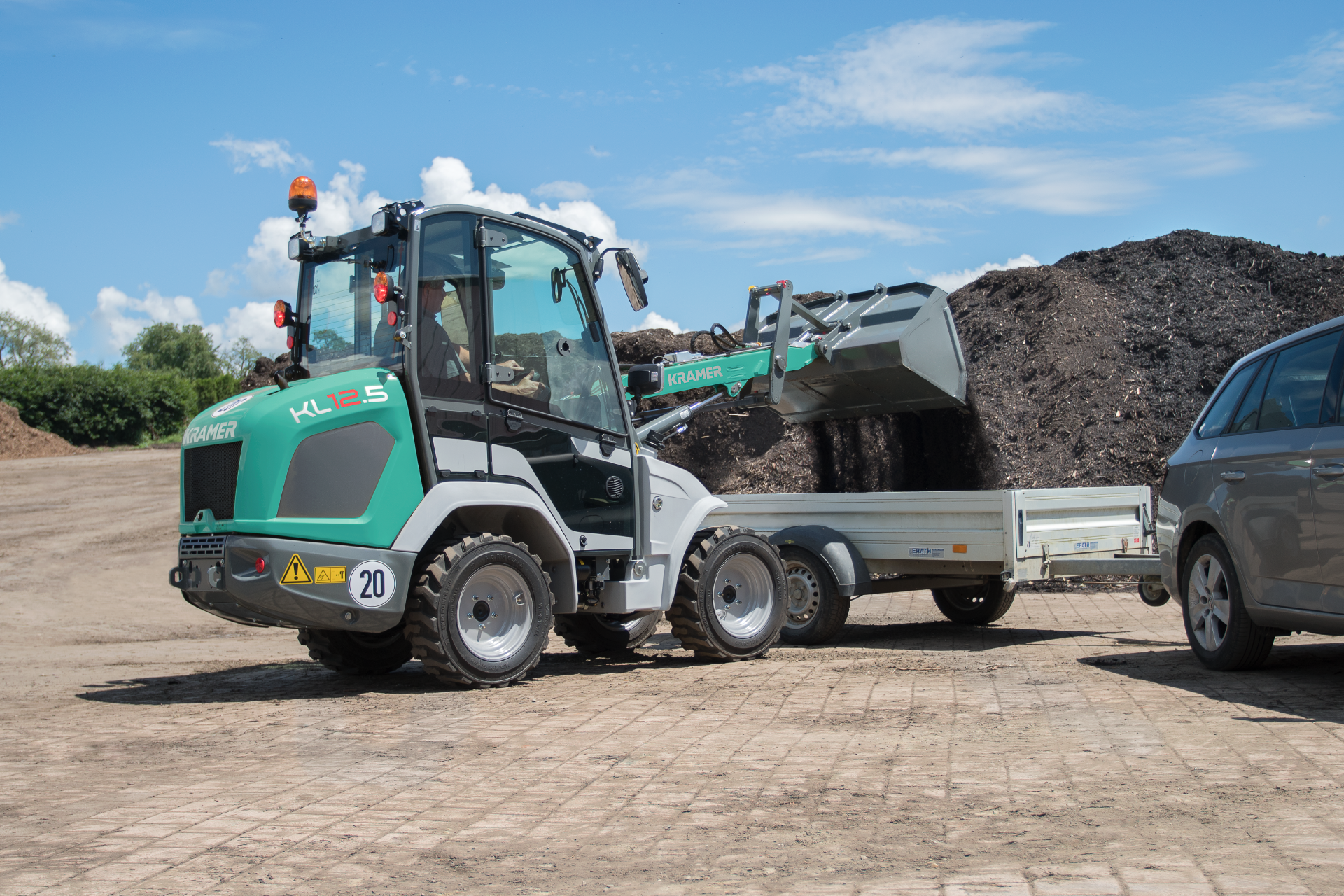 The compact KL12.5 while loading compost on a trailer.
