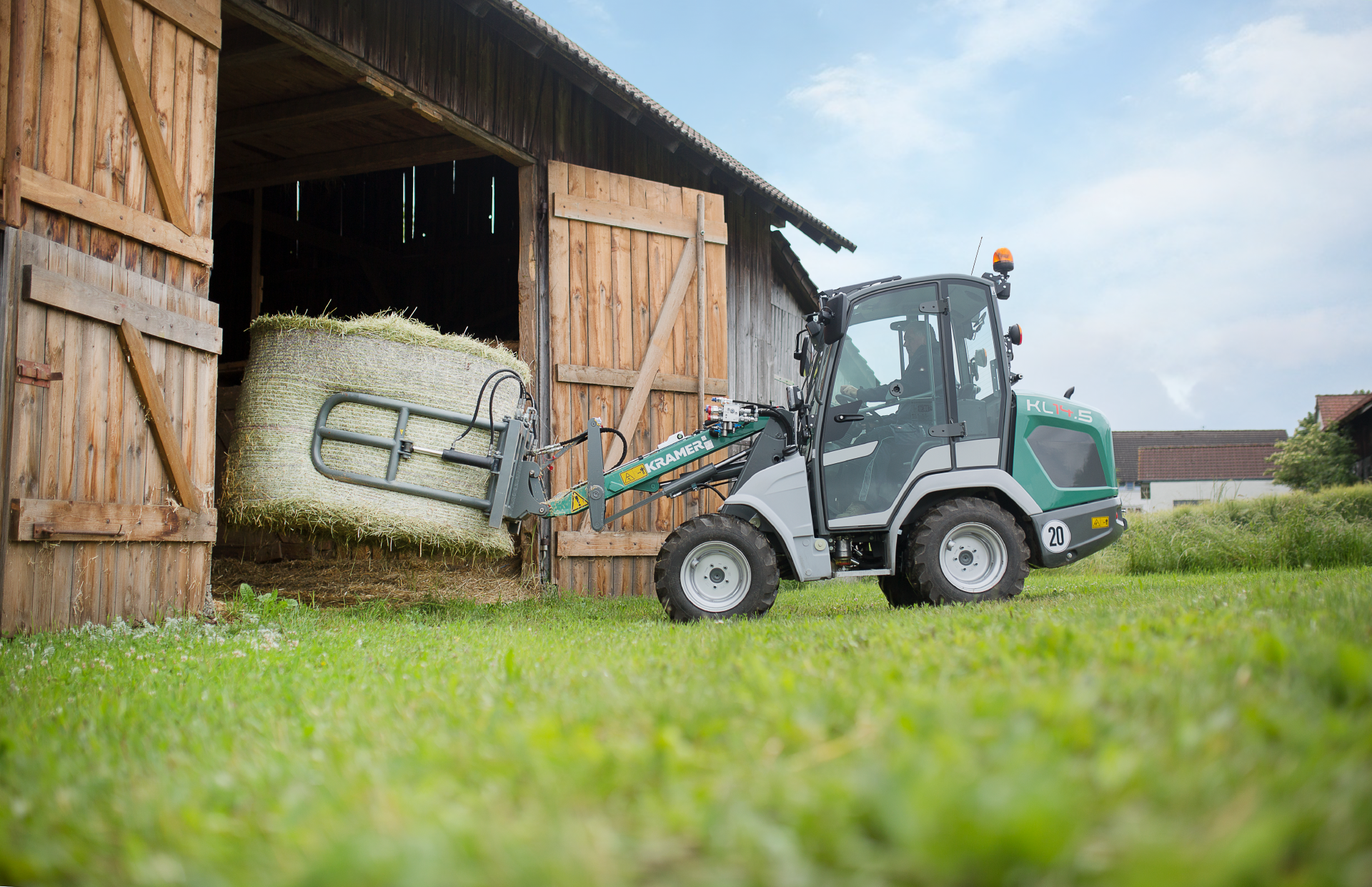 The compact KL14.5 while loading a straw bale through a stable gate.