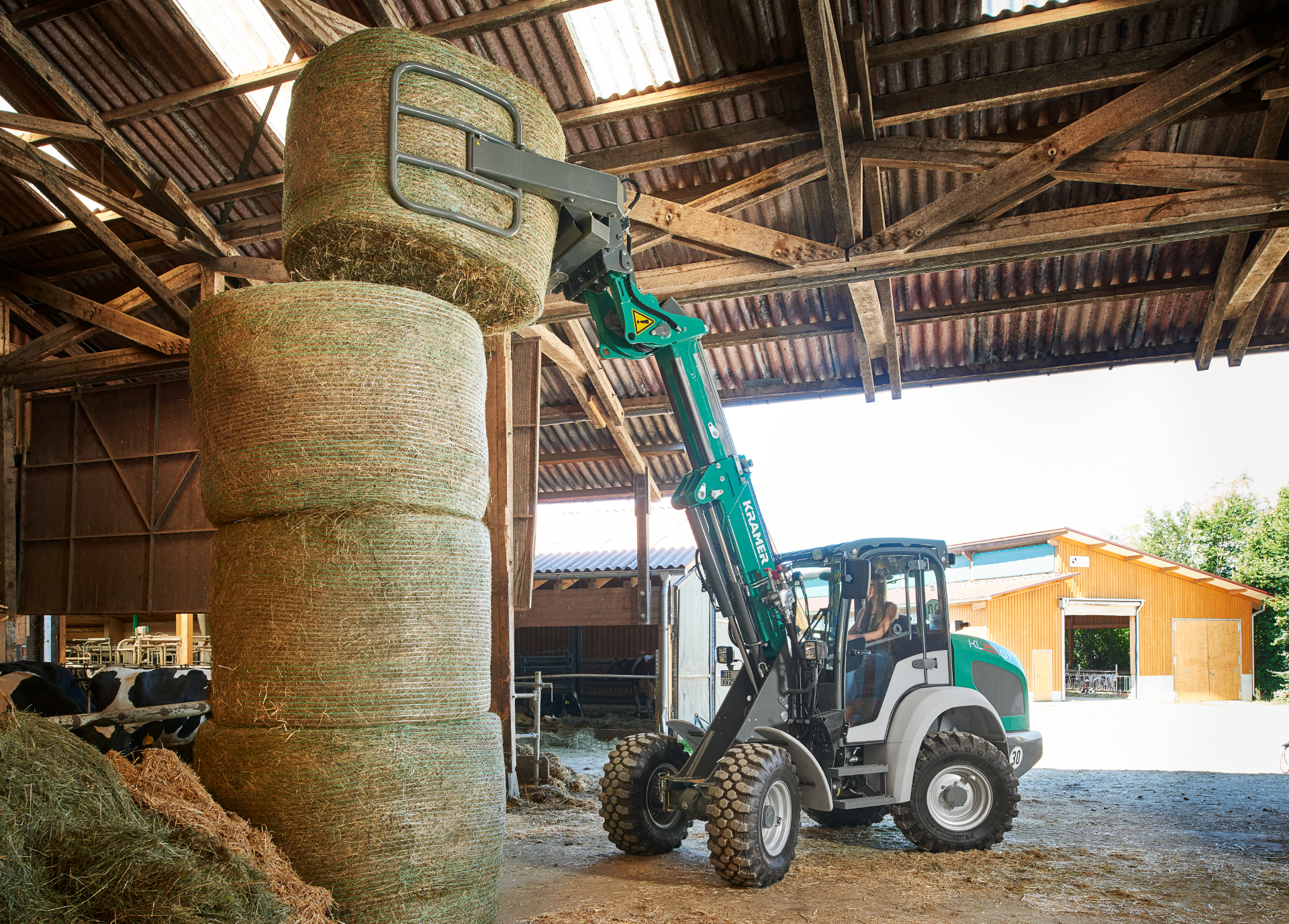 The Kramer telescopic wheel loader KL25.5T while loading bales on a field.