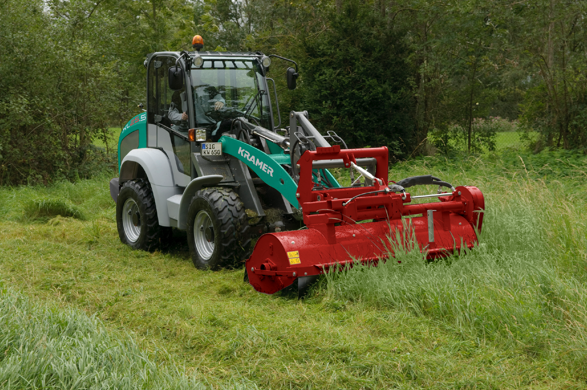 The Kramer wheel loader KL25.5 while doing mowe work on ameadow.