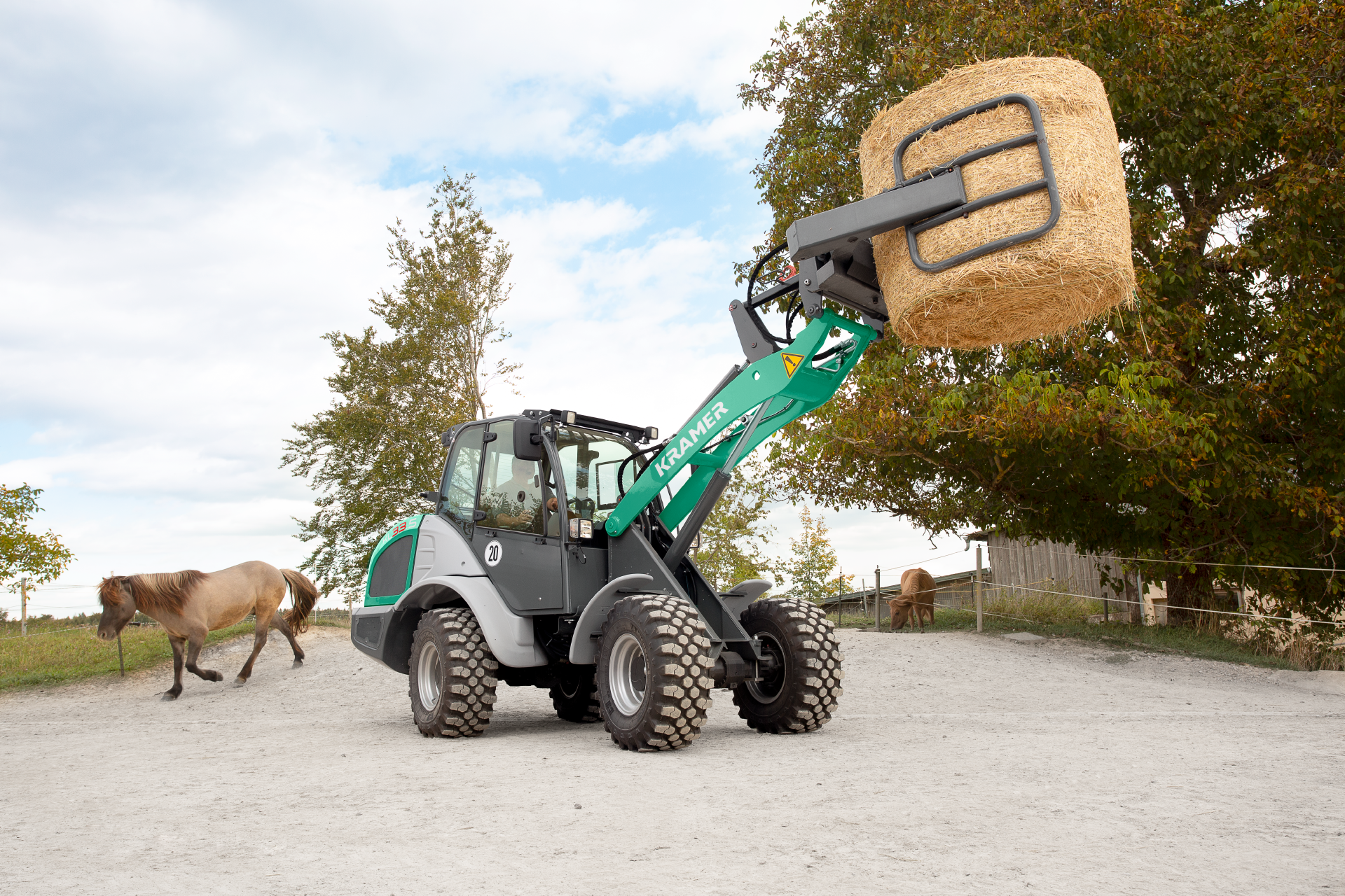 The Kramer wheel loader KL33.5 while loading straw with a bale clamp.